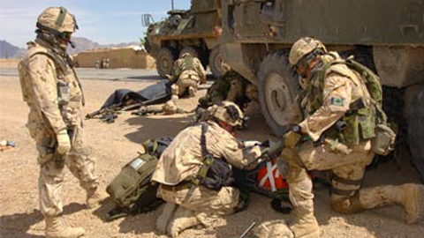 Canadian soldiers evacuate injured personnel after their armoured vehicle was struck by an oncoming vehicle outside of Kandahar City. The March 31, 2006, incident wounded two Canadian soldiers. (Robin Mugridge/Combat Camera/Canadian Forces)